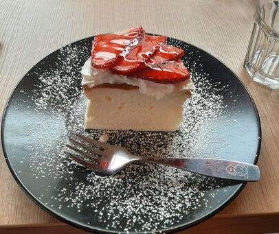 Japanese style cheesecake topped with whipped cream and glazed strawberries